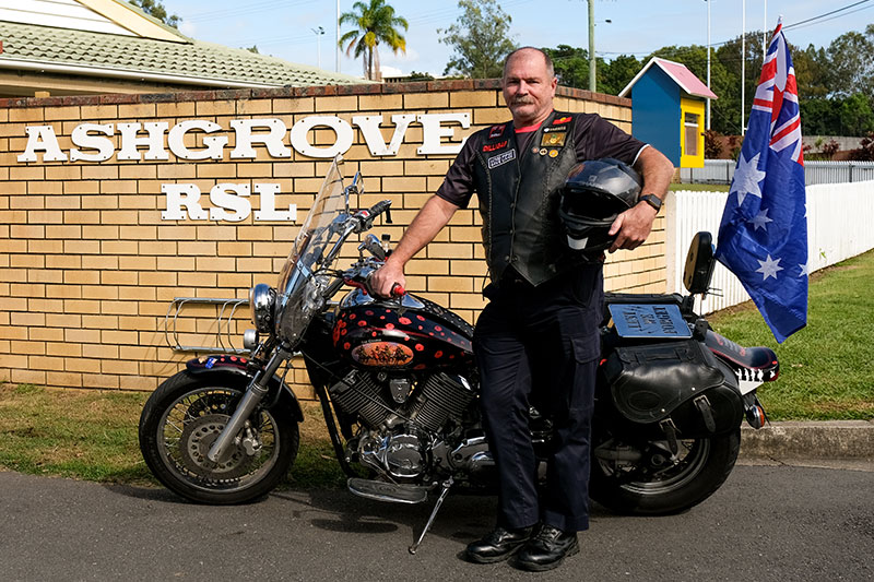 Ken Cook standing beside his motorbike parked at the Ashgrove RSL. 