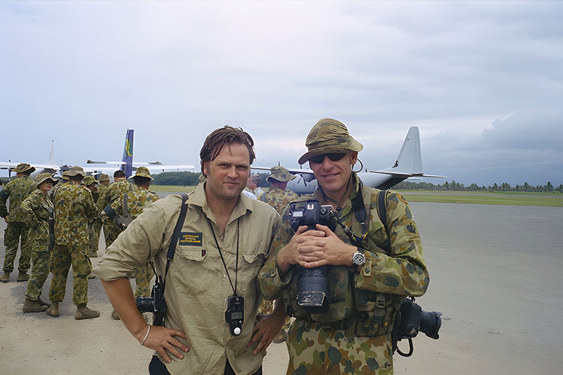 Image: AWM | Australian War Memorial Photographer Steve Dupont (left), and Warrant Officer Class 2 Gary Ramage (right), at Honiara airport in November 2003.
