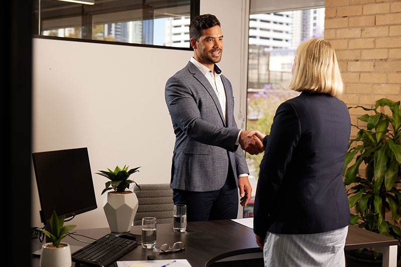 People shaking hands in an interview setting. 