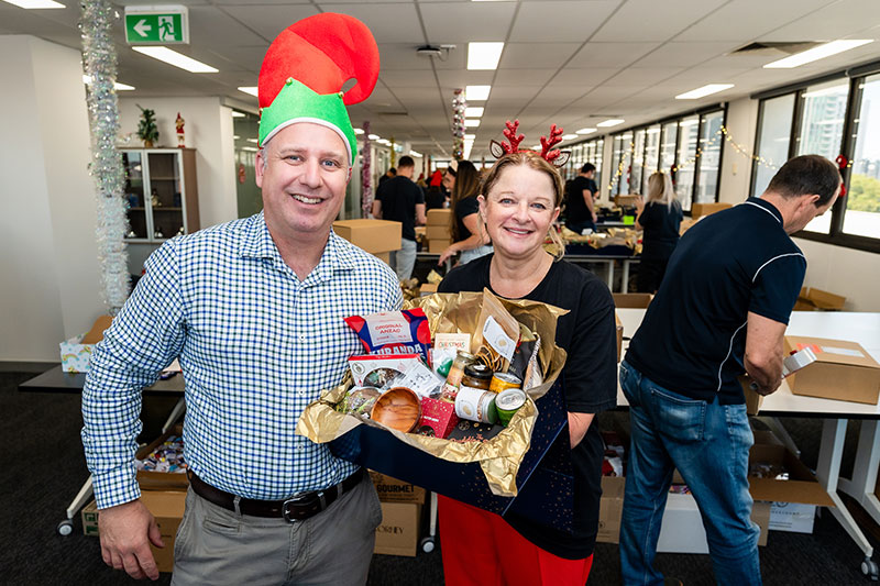 RSL Queensland CEO Rob Skoda and Executive General Manager Leigh Goldsmith standing together with a Christmas hamper. 