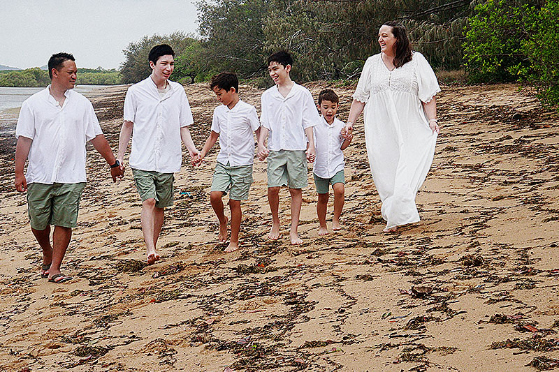 Cassandra Ladesma with her family walking along a beach. 